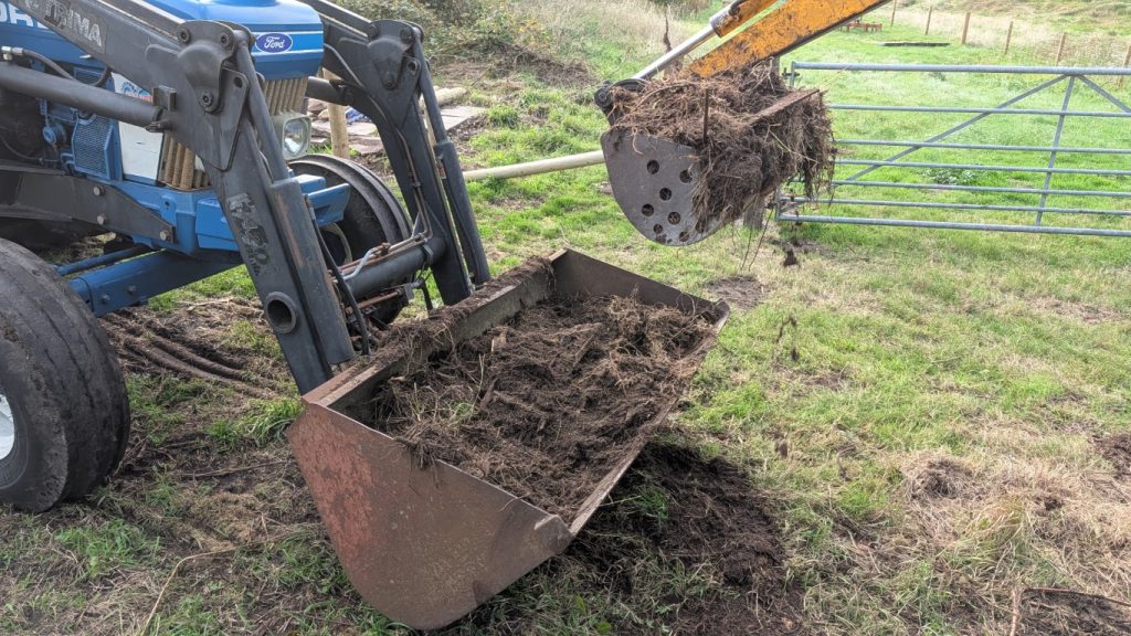 Digger and bucket cleaning up.