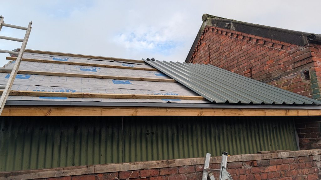 One sheet at a time, and the rear section of the roof goes up.