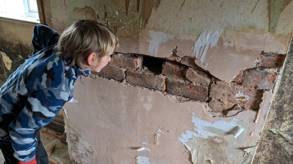 Mr Smashy uses a sledgehammer to access the old fireplace.